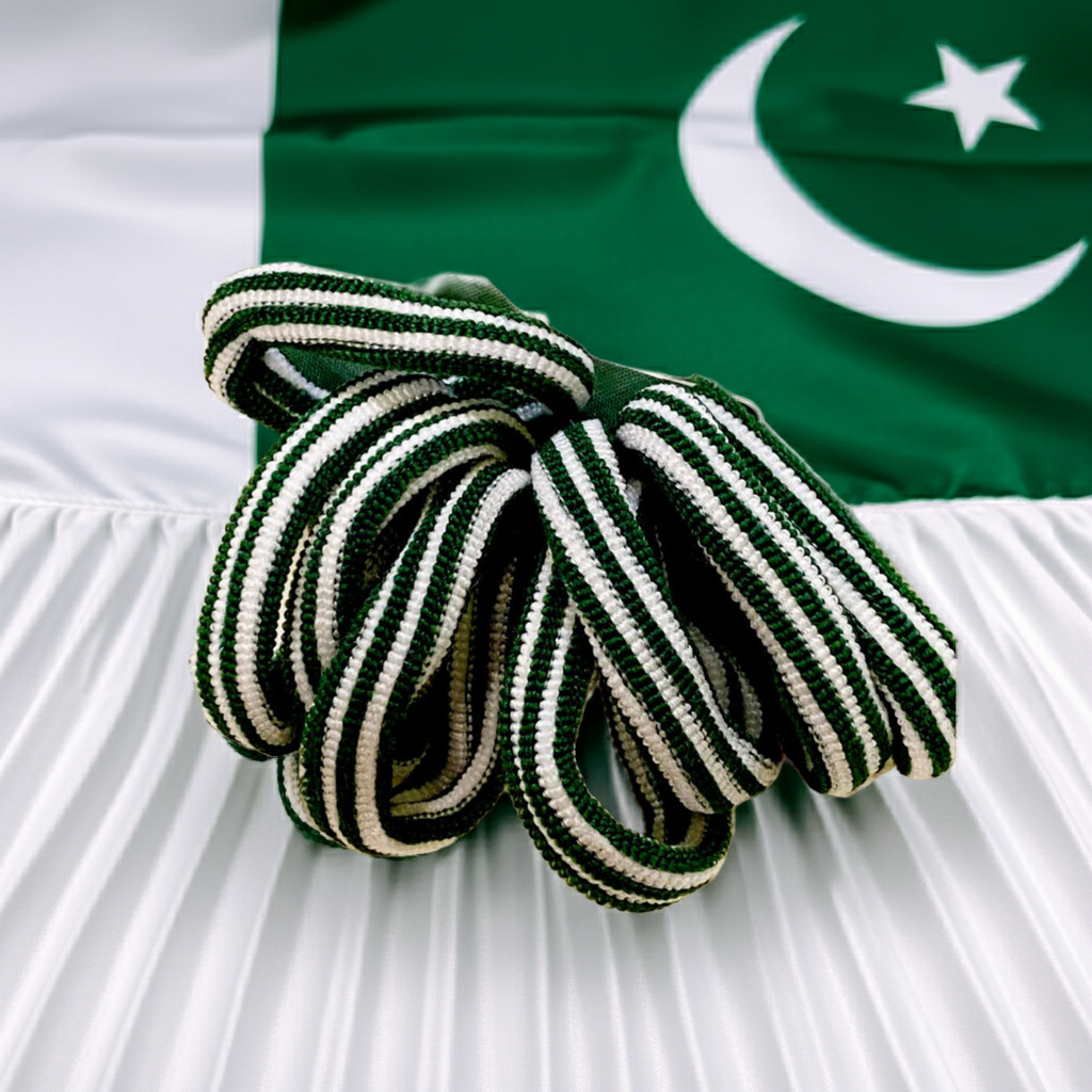 A coiled green and white striped rope or cord placed on a white pleated fabric surface with a green flag featuring a white crescent and star in the background.