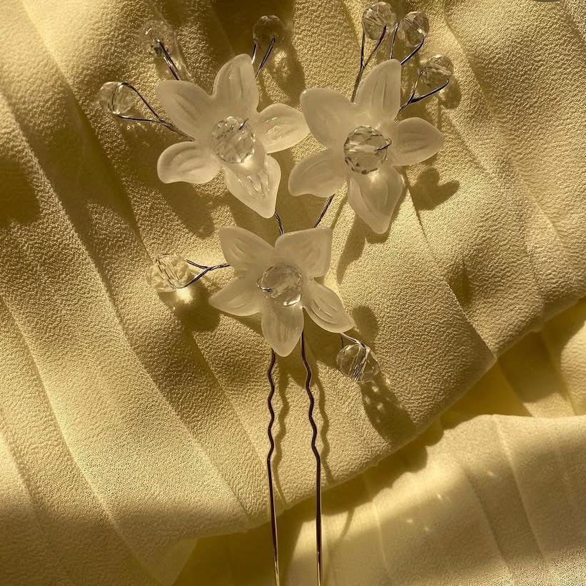 Floral hairpins with crystals on a textured beige fabric background