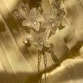Floral hairpins with crystals on a textured beige fabric background