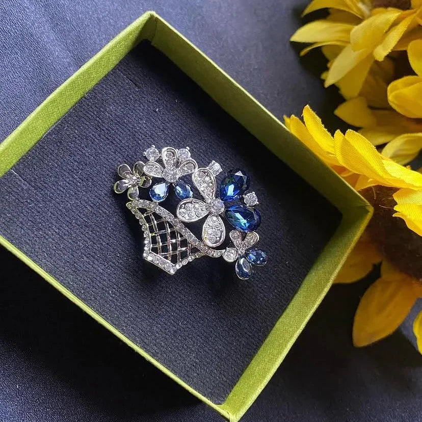 Decorative brooch in a box with yellow flowers on a dark surface