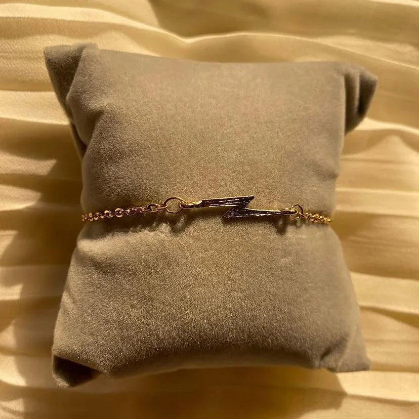 Bracelet with a lightning bolt design on a beige pillow