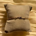 Bracelet with a lightning bolt design on a beige pillow
