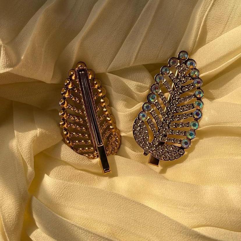 Two decorative hair clips on a yellow fabric background