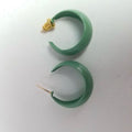 Green hoop earrings on a white background