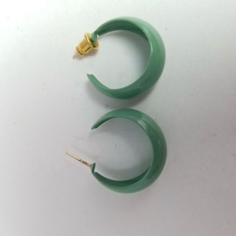 Green hoop earrings on a white background