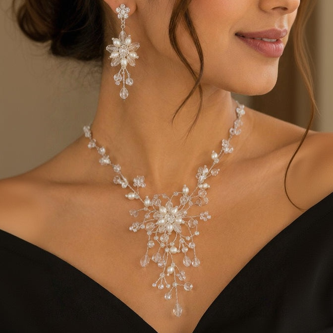 Woman wearing a sparkling necklace and earrings against a neutral background