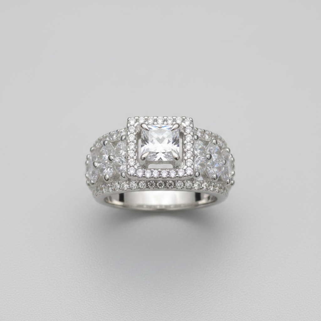 Silver ring with a large central gemstone and smaller stones on a gray background