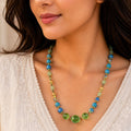 Woman wearing a colorful beaded necklace with a neutral background