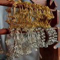 Set of gold and silver hoop earrings on a wooden stand.