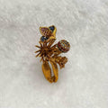 Gold brooch with gemstones on a white fabric background