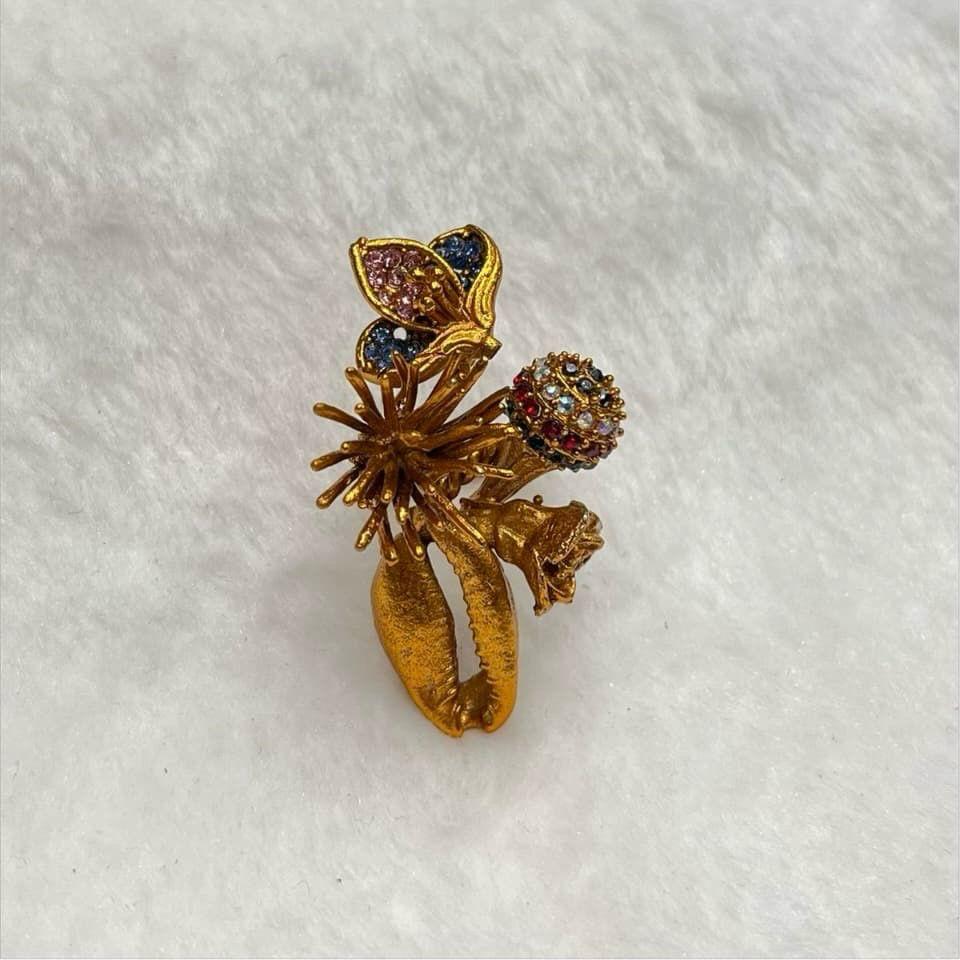 Gold brooch with gemstones on a white fabric background