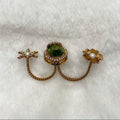 Gold earring with green gemstone and pearl on a white background