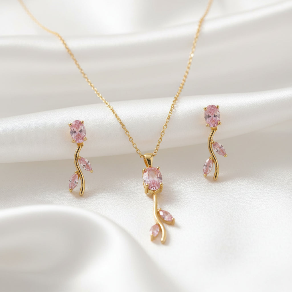 Gold necklace with pink gemstones on a textured surface