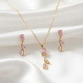 Gold necklace with pink gemstones on a textured surface