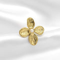 Gold flower-shaped brooch with a pearl center on a white satin background