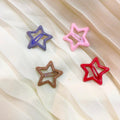 Four star-shaped hair clips in purple, pink, brown, and red on a sheer fabric background.
