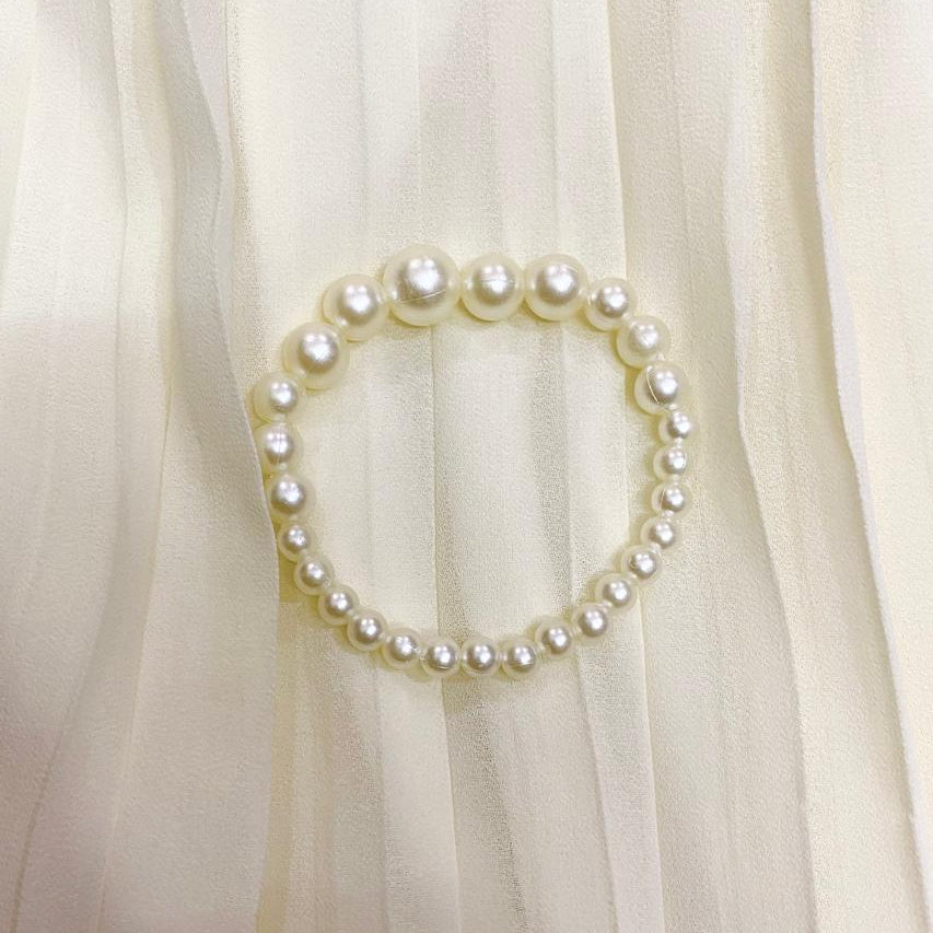 Pearl bracelet on a white fabric background