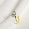 Gold earring with a diamond on a white fabric background