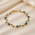 Gold bracelet with blue stones on a beige background