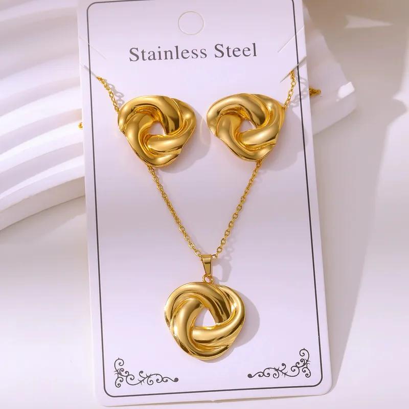 Gold knot necklace and earrings on a white card with 'Stainless Steel' text.