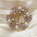 Decorative brooch with pearls and crystals on a beige fabric background