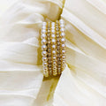 Set of pearl bracelets on a white fabric background