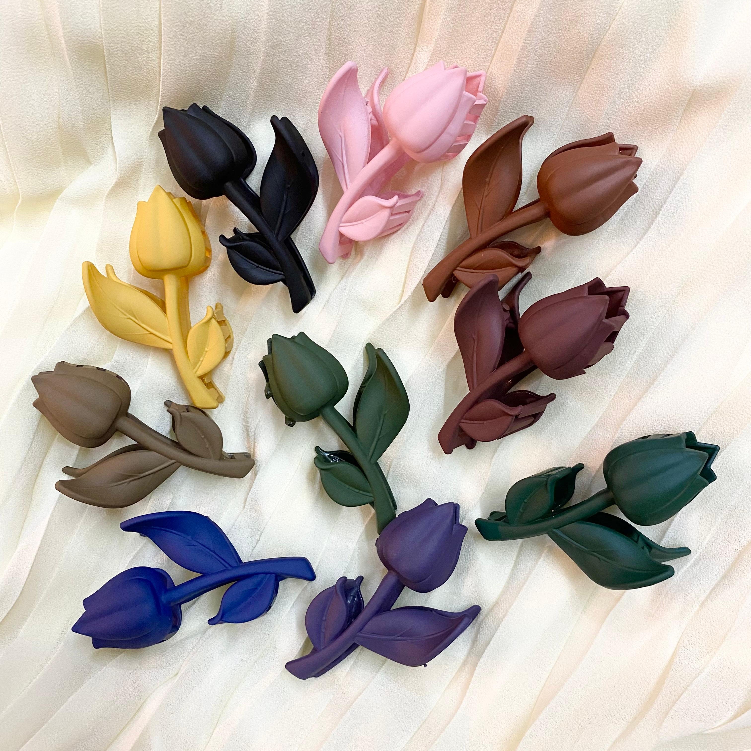 Colorful tulip-shaped hair accessories on a light fabric background