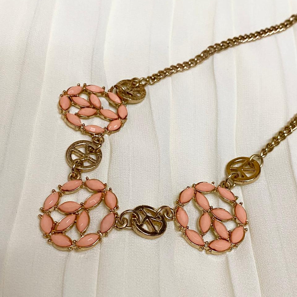 Necklace with pink floral pendants and gold chain on a white background