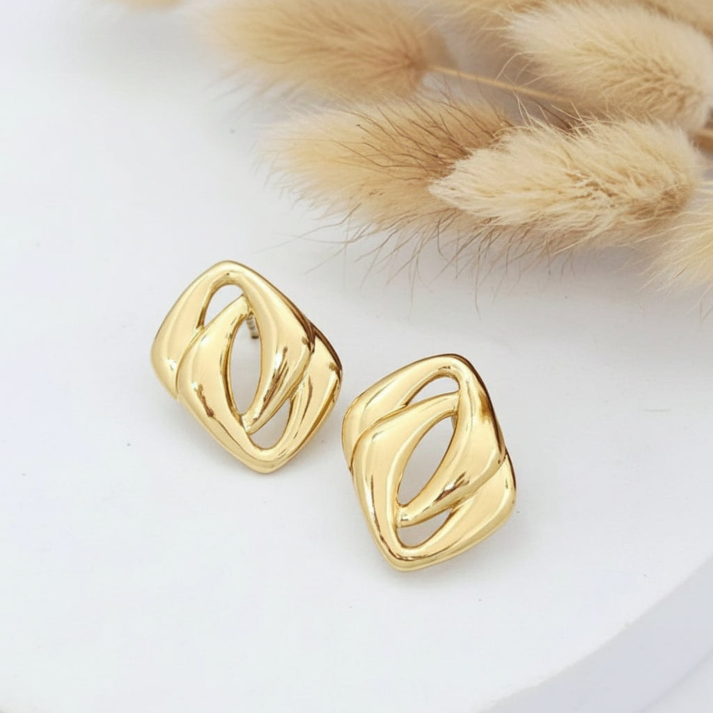 Gold earrings on a white surface with a fur texture background