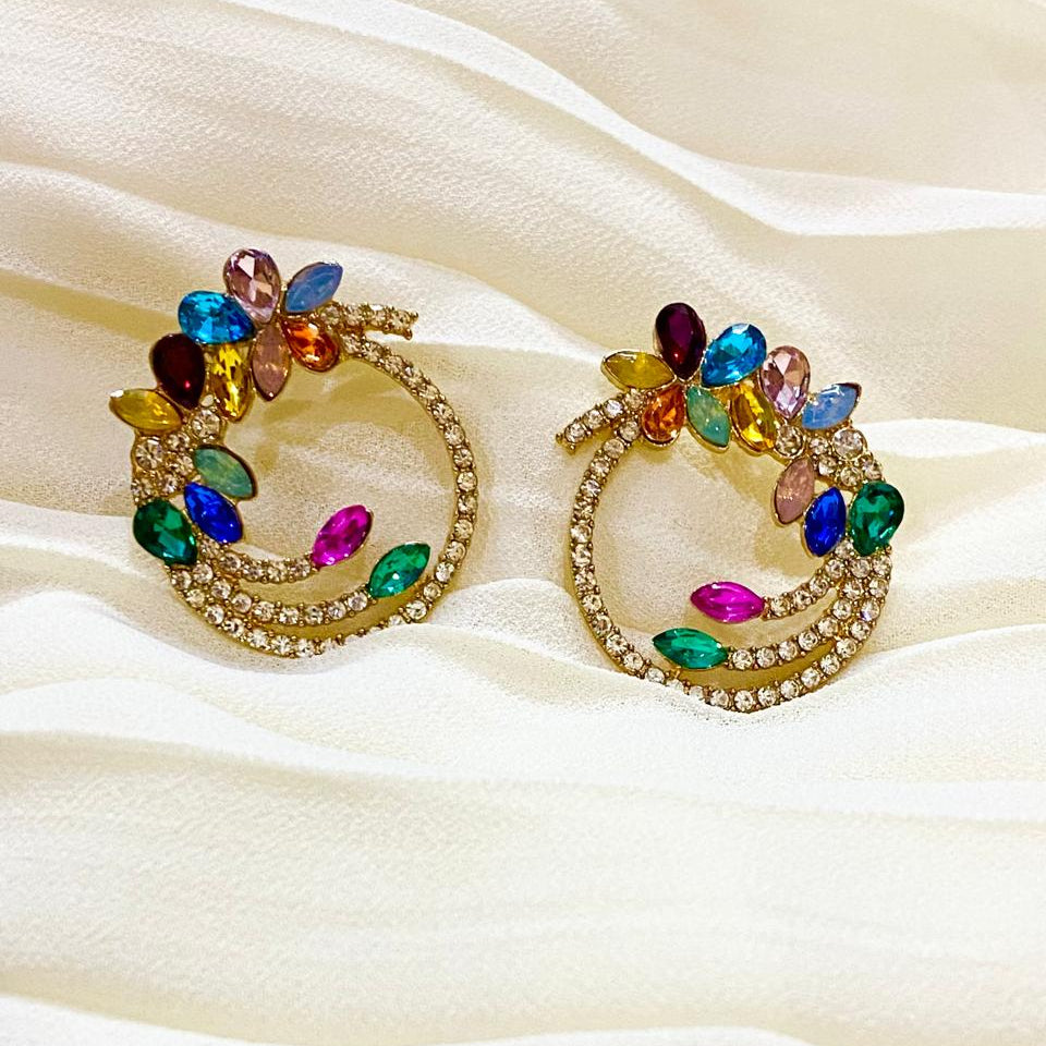 Colorful hoop earrings on a beige fabric background