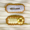 Two hair accessories on a white fabric background