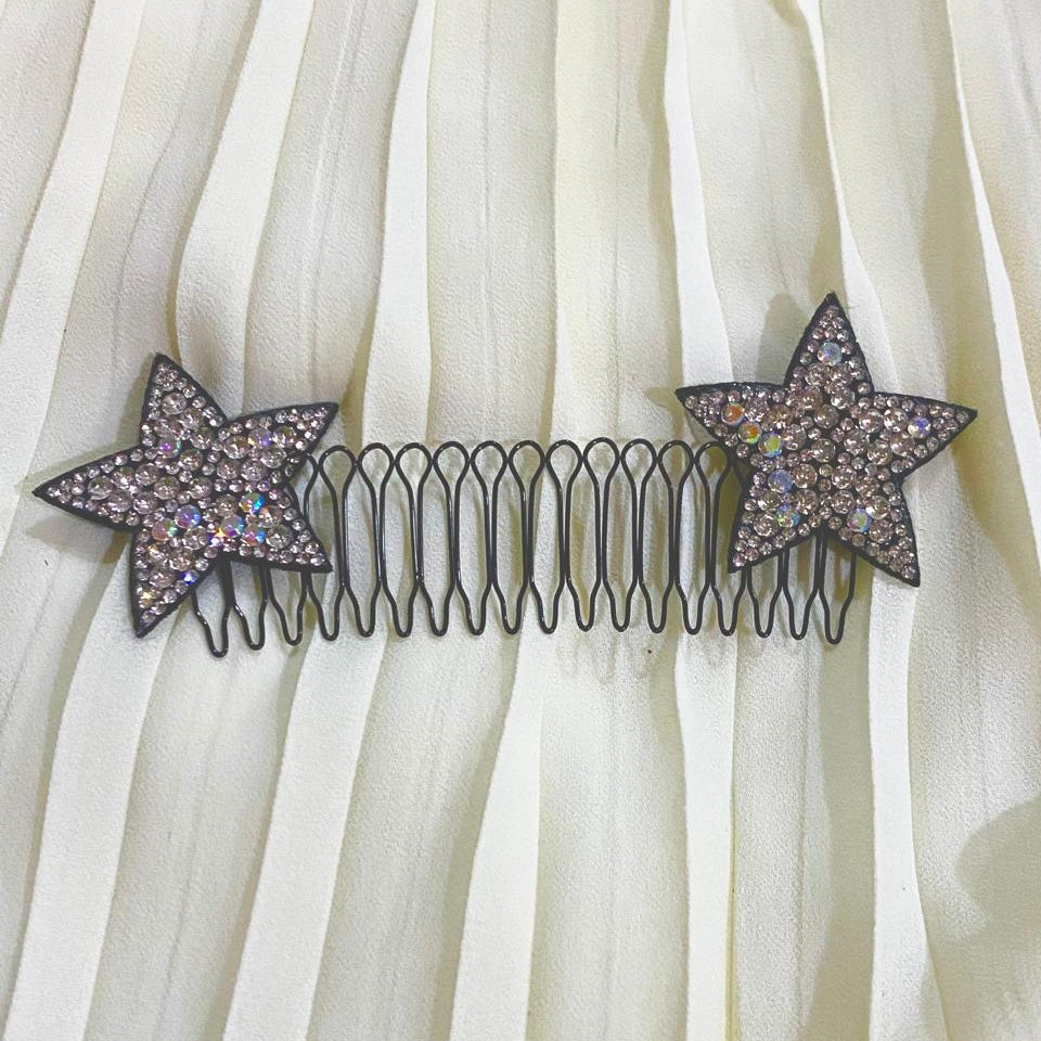 Star-shaped hair comb with rhinestones on a white fabric background