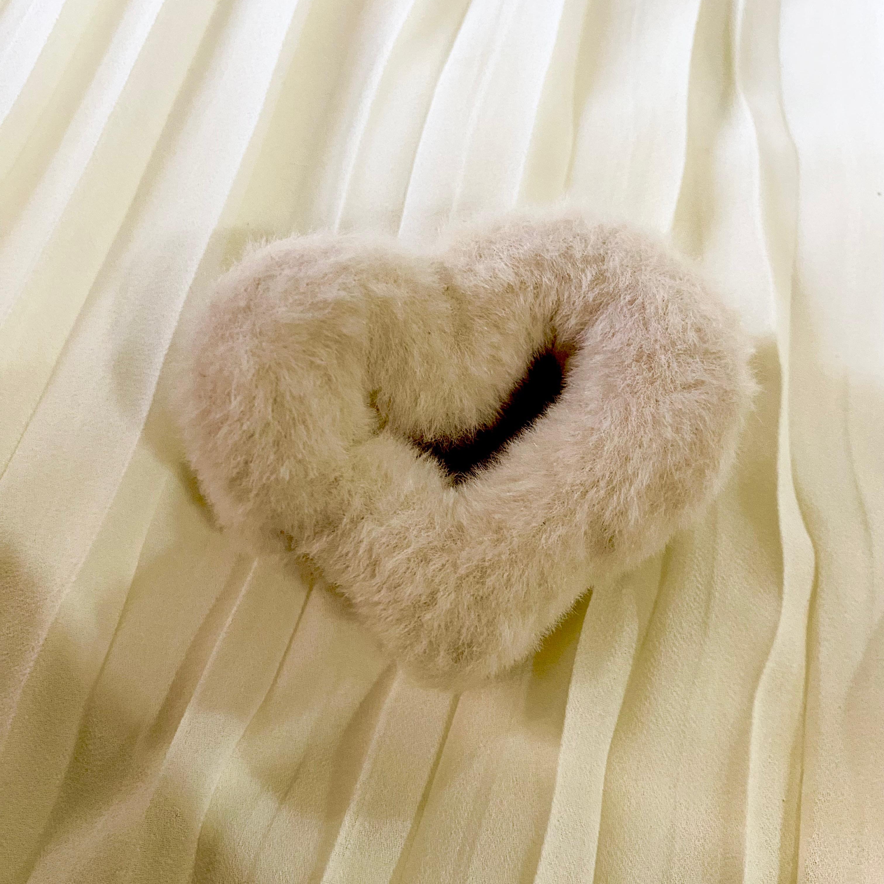 Heart-shaped fur product on a sheer white curtain