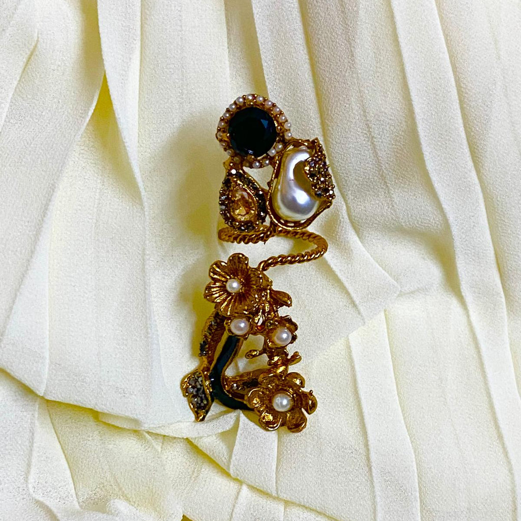 Ornate earring with gemstones on a white fabric background