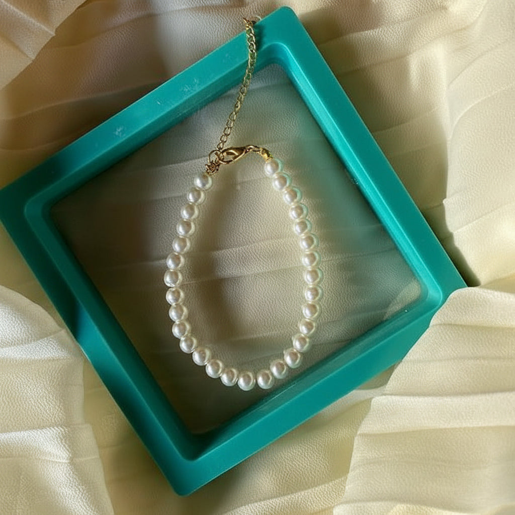 Pearl necklace in a turquoise box on a beige fabric background