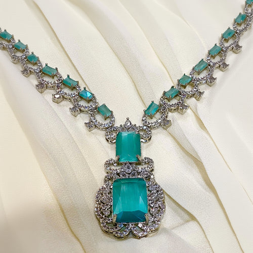 Turquoise necklace with silver chain on a beige fabric background