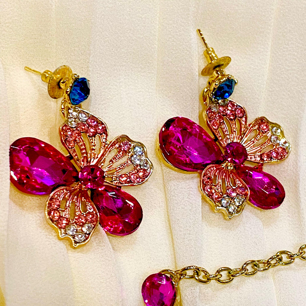 Butterfly-shaped earrings with colorful gemstones on a white background