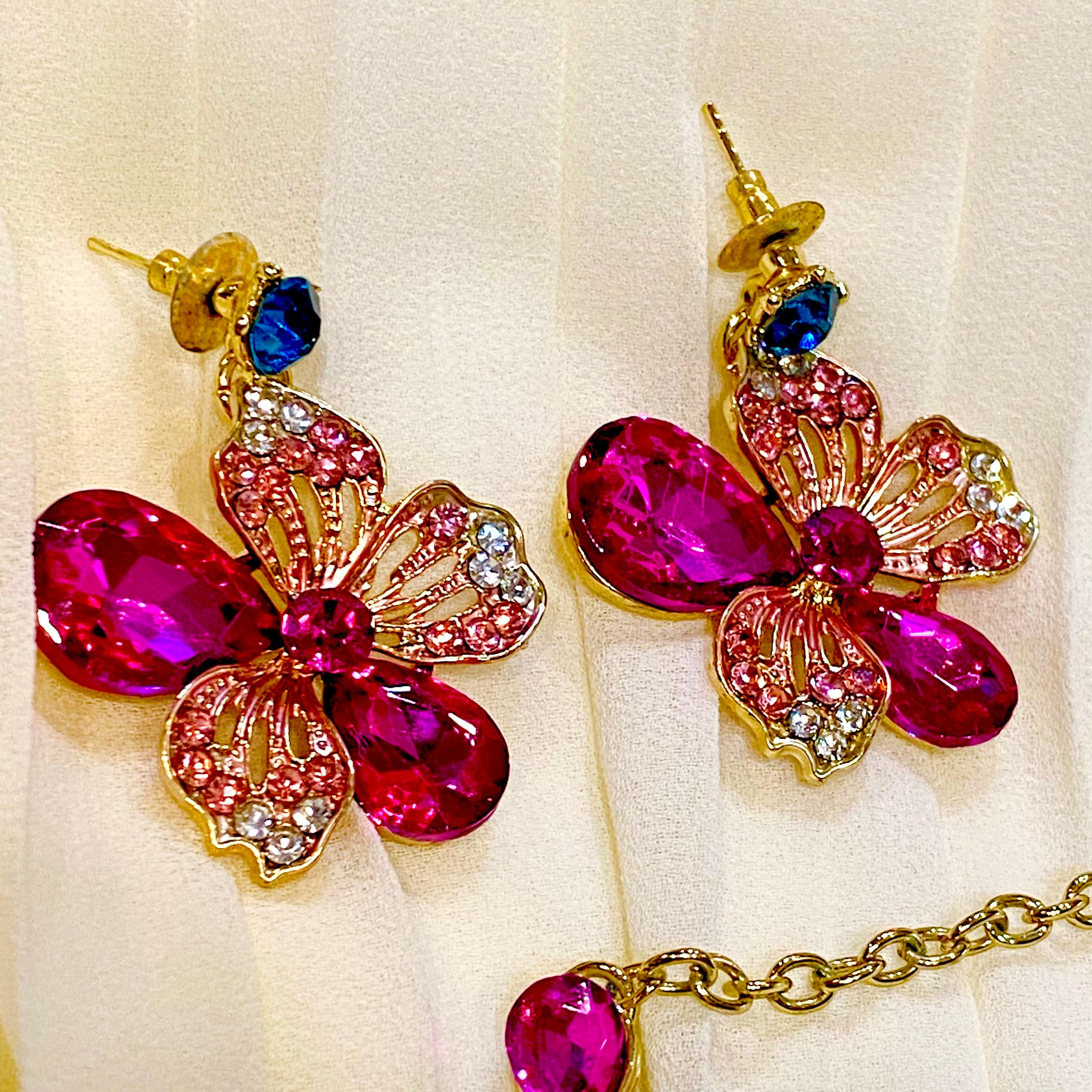 Butterfly-shaped earrings with colorful gemstones on a white background
